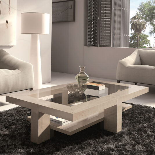 A modern living room features the Maple Veneer Rectangular Coffee Table With Glass Top, resting on a shaggy black rug. The table is decorated with a bowl and vase. Two beige armchairs flank the table, and a standing lamp illuminates the scene near a large window with shutters.