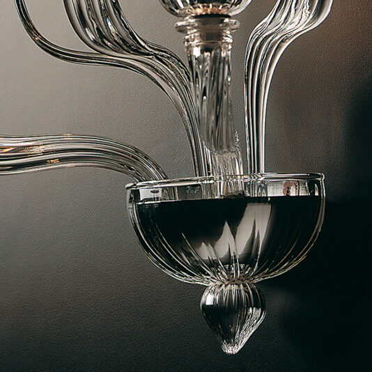 Classic Clear Glass Ribbed Detail Wall Light A close-up photograph of the Classic Clear Glass Ribbed Detail Wall Light. The image highlights the elegant and intricate ribbed details of the light's arms and glass bowl, showcasing the timeless craftsmanship and clarity of the clear glass against a neutral, softly lit background.
