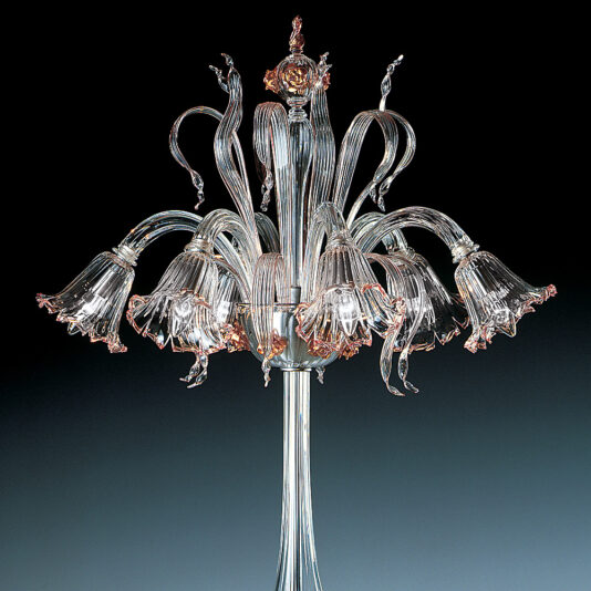 Classic Floral Detail Table Lamp A delicate, classic glass chandelier with multiple floral-shaped lights extending outward like blooming flowers, accented with subtle hues of pink and gold. The intricate design stands out against a dark gradient background, showcasing fine craftsmanship reminiscent of the Classic Floral Detail Table Lamp.