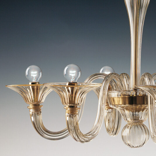 A detailed photograph of the Classic Gold Glass Ribbed Detail Chandelier showcases its six arms, each adorned with a clear light bulb. The elegant ribbed glass designs and polished metallic elements are beautifully illuminated, reflecting light against a background that transitions from dark to light, enhancing the chandelier's brilliant shine.