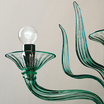 Classic Green Glass Ribbed Detail Wall Light A close-up image of the Classic Green Glass Ribbed Detail Wall Light with an exposed bulb. The ribbed detail enhances its artistic, wavy design, evoking organic, flowing shapes. The background is a plain off-white wall, allowing the elegant fixture to stand out beautifully.