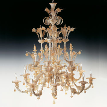 Large Classic Murano Glass Chandelier The Large Classic Murano Glass Chandelier features multiple tiers of intricate glasswork and candle-shaped bulbs. Adorned with elaborate floral and leaf designs, this ornate piece exudes luxury and elegance when set against a gradient background transitioning from white to black.