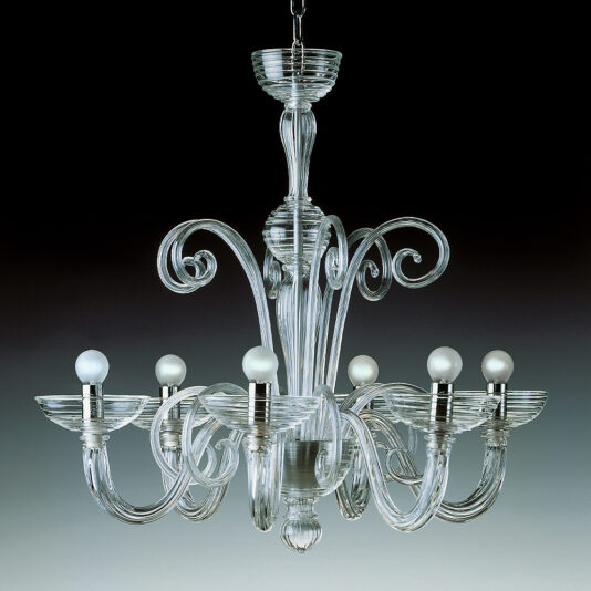 The Classic Swirl Detail Glass Chandelier is an elegant piece with intricate swirl designs, featuring eight bulbs arranged in a circular pattern. Suspended from a central chain, the chandelier's delicate craftsmanship is highlighted against a background that transitions from dark to light.