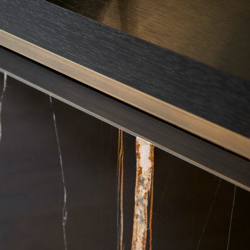 Luxury Marble Radiator Cover Console Close-up of the Luxury Marble Radiator Cover Console featuring a wood grain texture on top, a metallic accent strip in the middle, and a marble-like finish with white and orange veins on the lower part. This modern console exudes elegance with its sleek and polished materials.