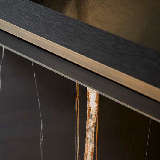 Close-up of the Luxury Marble Radiator Cover Console featuring a wood grain texture on top, a metallic accent strip in the middle, and a marble-like finish with white and orange veins on the lower part. This modern console exudes elegance with its sleek and polished materials.
