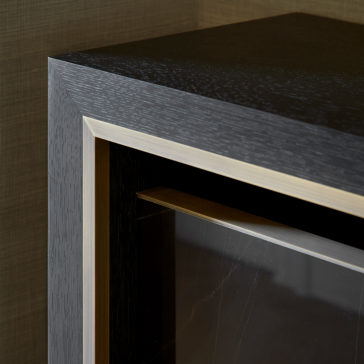 Luxury Marble Radiator Cover Console Close-up view of a corner of the Luxury Marble Radiator Cover Console, showcasing its dark wood texture and metallic frame. The console features a glass panel and boasts a sleek, minimalist design. The background wall is subtly textured.