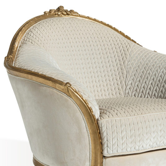 Luxury Venetian Style Armchair A close-up of the Luxury Venetian Style Armchair showcases its elegant, cream-colored, tufted upholstery with a refined herringbone pattern. The gold frame and intricate gold carvings at the top of the backrest enhance its vintage and luxurious appeal.