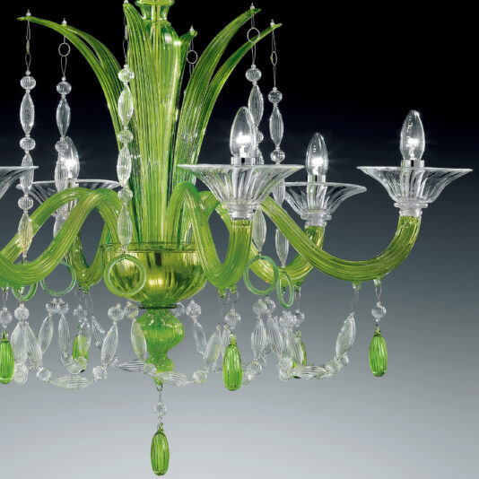 Statement Green Crystal Drop Chandelier The Statement Green Crystal Drop Chandelier is a brightly lit fixture featuring a mix of green and clear glass elements. It boasts five curved green glass arms adorned with crystal-like hanging ornaments and candle-shaped light bulbs, all set against a gradient dark background.