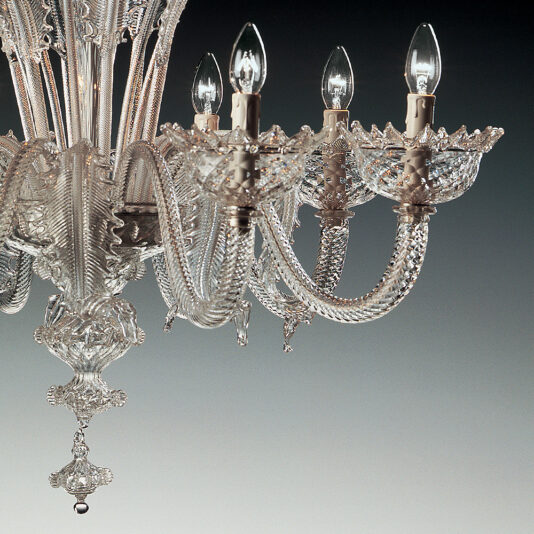 Classic Floral Clear Glass Chandelier The Classic Floral Clear Glass Chandelier is showcased in all its elegance, with intricate detailing and multiple glass arms holding candle-shaped light bulbs. The classic clear glass elements shimmer and reflect light, creating a sophisticated and luxurious appearance against a gradient gray background.