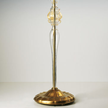 Classic Floral Gold Glass Floor Lamp The Classic Floral Gold Glass Floor Lamp boasts an ornate, transparent glass body adorned with golden highlights and a decorative flourish near the top. Its rich, polished gold base features a gently ridged design, standing gracefully on a plain white background.