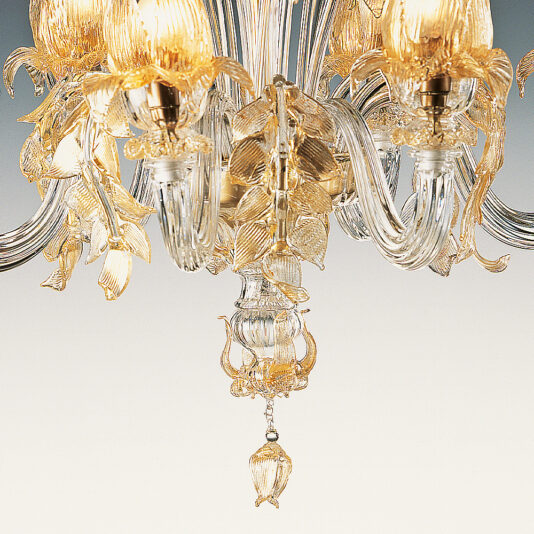Classic Floral Gold Glass Chandelier A detailed view of the Classic Floral Gold Glass Chandelier, showcasing its intricate glass and metalwork. This luxurious piece features a classic design with multiple arms adorned with ornate leaves, flowers, and hanging crystal pendants. Each part is illuminated by glowing light bulbs that create a warm ambiance.
