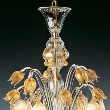 The Classic Floral Gold Glass Chandelier features ornate floral designs, gold-toned details, and glass tulip-shaped lampshades. Its central column supports curved arms with glowing lamps that create intricate glasswork, casting a warm glow throughout the room.