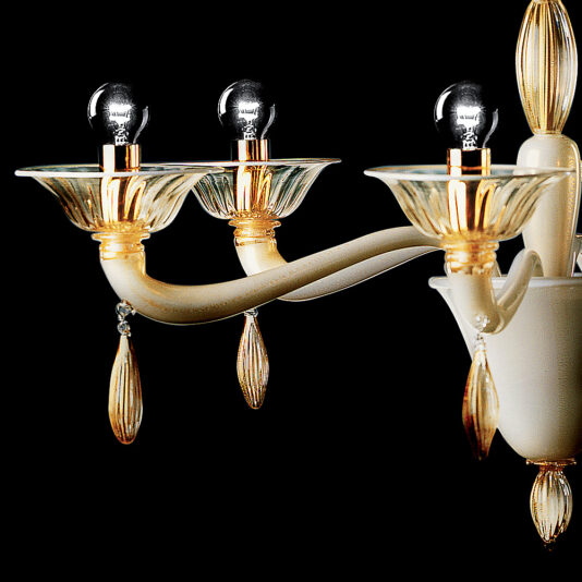 A detailed view of the Classic Gold Glass Chandelier With Gold Frame, showcasing its three gold-plated arms, each adorned with a glass bulb holder and lightbulb. The chandelier boasts ornate gold embellishments and teardrop-shaped glass pendants, all beautifully set against a black background.