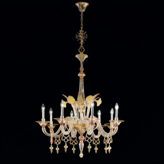 The Classic Ornate Gold And Red Glass Chandelier is a luxurious crystal chandelier with an intricate design, featuring multiple ornate arms, each holding a lit candle-shaped bulb. This classic piece boasts decorative elements, all beautifully suspended against a black background.
