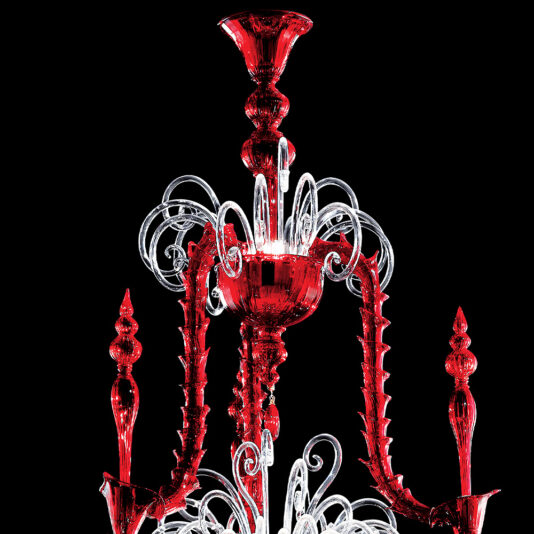 Classic Ornate Red Glass Chandelier The Classic Ornate Red Glass Chandelier is a striking timeless piece featuring an intricate design with ornate red and clear glass elements. It boasts multiple curled arms and decorations, all set against a black background that emphasizes the vibrant colors and elaborate details.