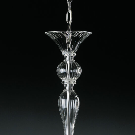 A close-up of the Clear Ribbed Detail Glass Chandelier part against a black background. The design features intricate curves, clear ribbed patterns, and a bulbous center section, leading to a tapered end, all crafted from transparent glass.