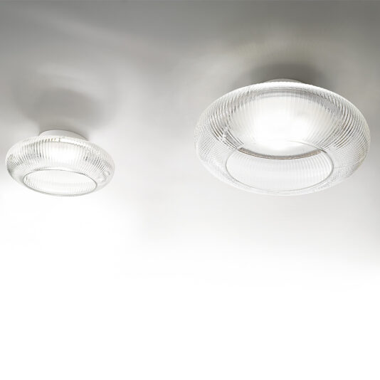 Contemporary Ribbed Glass Ceiling Light The Contemporary Ribbed Glass Ceiling Lights feature a sleek, circular design with a textured glass finish. These lights emit a soft, diffused glow that enhances the ambient atmosphere of any room. One light is slightly smaller and positioned lower than the other for a layered lighting effect.