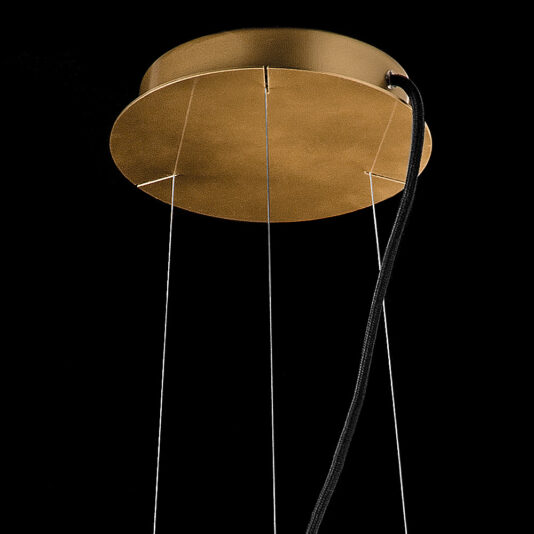 Here's a close-up view of the Contemporary Ribbed Glass Pendant Light With Gold Frame, featuring a round, gold-colored canopy. Thin wires extend from the canopy to suspend the fixture, with a black cord also attached for additional support. Set against a black background, this elegant pendant light stands out beautifully with its gold frame.