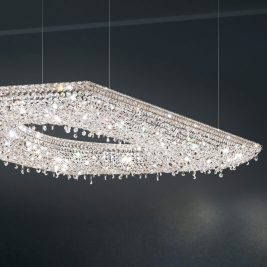 The Contemporary Suspended Crystal Pendant Chandelier, featuring an elongated oval design and adorned with numerous sparkling crystals, hangs from the ceiling against a dark background. The crystals reflect light, creating a dazzling and elegant display.