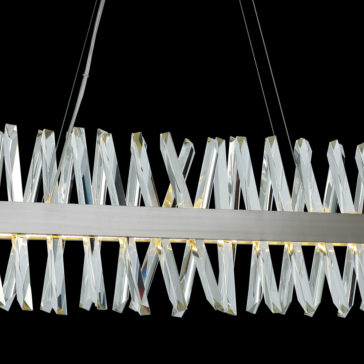 Narrow Nickel Crystal Chandelier The Narrow Nickel Crystal Chandelier boasts a sleek, modern design with a row of elongated, twisted crystal-like elements arranged in an eye-catching zigzag pattern. Suspended by thin wires against a black background, this fixture highlights its contemporary and elegant aesthetic.
