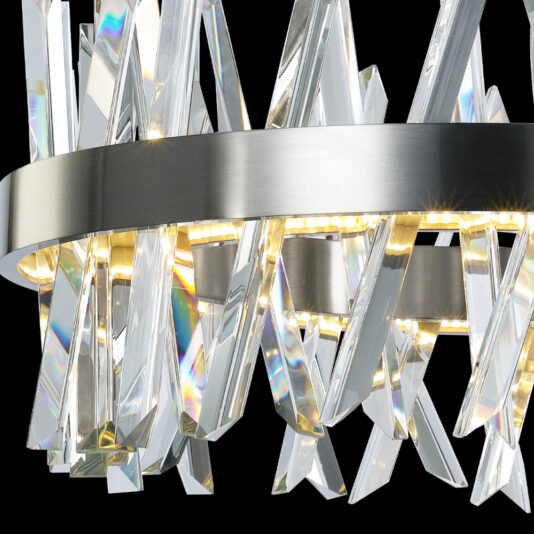 Exclusive Round Nickel Chandelier A close-up of the Exclusive Round Nickel Chandelier, showcasing its brushed metal circular frame that encases numerous angular crystal pieces. These crystals beautifully reflect light and are illuminated by embedded LED lights, resulting in a dazzling and contemporary lighting fixture.