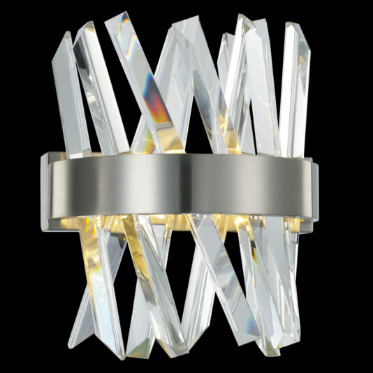 Exclusive Small Nickel Pendant Light A modern wall sconce with a brushed metal base holds clear, angular crystal prisms arranged in a crisscross pattern. The prisms reflect light to create a dynamic, sparkling effect that is both stylish and elegant against the black background. Pair it with the Exclusive Small Nickel Pendant Light for added sophistication.