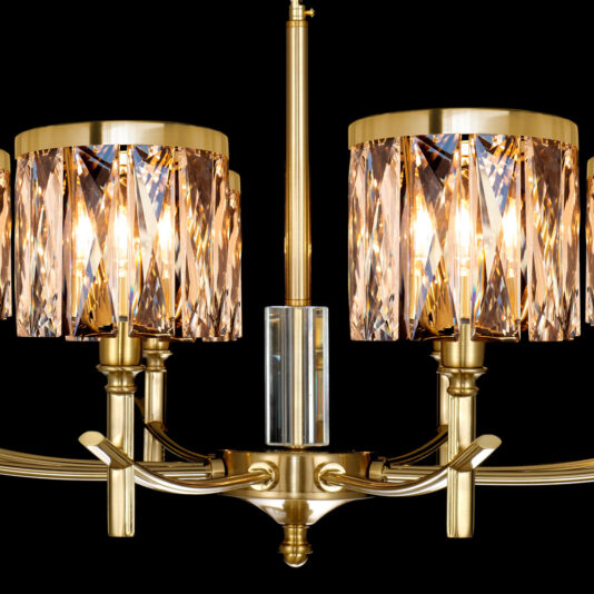A close-up view of the High End 8 Arm Gold Chandelier reveals its luxurious design with two lamps. Each lamp features a gold base adorned with prism-like crystal ornaments surrounding the light bulbs, casting a warm and elegant glow. The chandelier is set against a black background, which accentuates its ornate details.