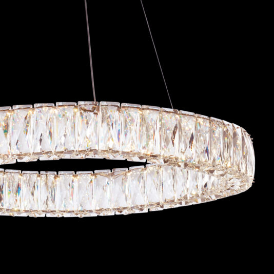 Luxury Round Crystal Chandelier The Luxury Round Crystal Chandelier features an exquisite design with numerous large, multifaceted crystal prisms meticulously arranged around its circular frame, creating a dazzling, sophisticated glow. Suspended by nearly invisible thin wires against a sleek black background, it adds a touch of elegance to any space.