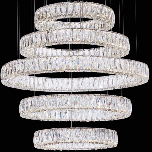 Luxury Five Ring Crystal Chandelier The Luxury Five Ring Crystal Chandelier features multi-tiered, concentric circular rings adorned with sparkling clear crystals, all elegantly suspended by thin wires against a black background. The crystals reflect light to create a dazzling and elegant display.