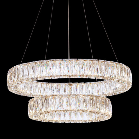 The Luxury Tiered Crystal Chandelier features two circular tiers and is suspended by thin wires against a black background. It is adorned with numerous faceted crystal prisms that reflect and refract light, producing a luxurious and elegant effect.
