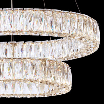 Luxury Tiered Crystal Chandelier The image showcases a close-up view of the Luxury Tiered Crystal Chandelier, featuring two concentric rings elegantly decorated with large, multi-faceted crystals. These crystals sparkle brilliantly against a black background, reflecting light in an array of colors.