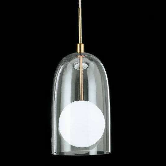 The Contemporary Long Glass Dome Pendant Light features a sleek, clear glass shade with a white, round light diffuser inside. A brass stem connects it to the suspension wire, and its modern design is accentuated by the solid black background.