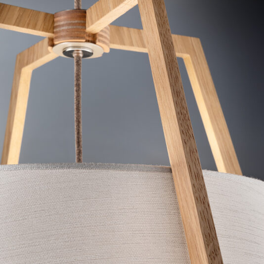 Modern Oak Frame Pendant Light Close-up of the Modern Oak Frame Pendant Light, featuring a natural oak wooden frame and a fabric-covered lampshade. The lamp hangs from a cord against a neutral background, highlighting its minimalist design and material texture.