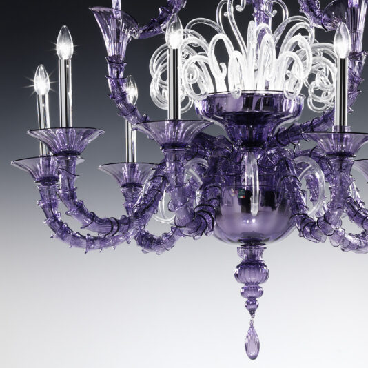 Classic Ornate Purple Glass Chandelier The Classic Ornate Purple Glass Chandelier showcases an intricate design with purple glass arms and candle-like light bulbs. This elegant fixture includes clear glass decorative elements at the top and hangs beautifully against a gradient background transitioning from white to gray.