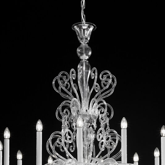 Ornate Traditional Clear Glass Chandelier A close-up of the Ornate Traditional Clear Glass Chandelier against a black background. This exquisite piece showcases intricate detailing with candle-style lights and elaborate clear glass designs, exuding a luxurious and elegant appearance. The light bulbs, shaped like candles, emit a soft glow.