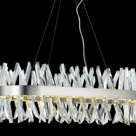 Oval Crystal And Nickel Chandelier A modern chandelier with a sleek, oval metallic frame adorned with crisscrossing, translucent crystal-like elements. It is suspended by thin wires against a black background, emitting a soft, warm glow.