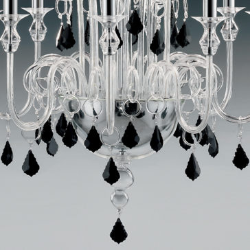 Traditional Chandelier With Black Crystal Drops Close-up of a Traditional Chandelier With Black Crystal Drops, featuring intricate glass detailing and teardrop-shaped black crystal drops. The transparent glass arms curl outwards, holding candle-like fixtures, with additional black crystal pendants hanging from various points that reflect light brilliantly.