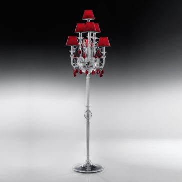 Traditional Floor Lamp With Red Crystal Drops The Traditional Floor Lamp With Red Crystal Drops is an elegant silver fixture standing tall with multiple red lampshades and decorative red crystals. This classic, luxurious floor lamp features intricate detailing and rests on a shiny, broad metallic base, all showcased against a gradient black and white background.