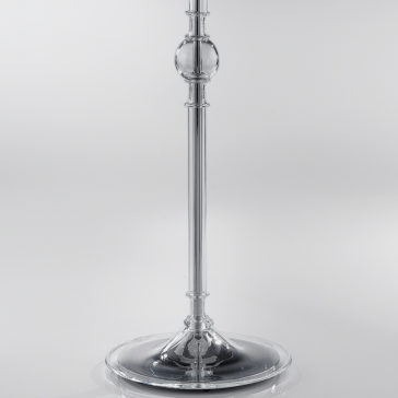 Traditional Floor Lamp With Red Crystal Drops A close-up view of a sleek, transparent glass candlestick holder. The holder features a round base and a tall, slender stem with a decorative glass orb in the middle. Its elegance is reminiscent of the **Traditional Floor Lamp With Red Crystal Drops**. The glass reflects light, giving it a shiny appearance.