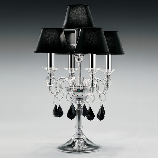 The Traditional Table Lamp With Black Crystal Drops features a candelabra design with five black lampshades and intricate black crystal drops. This decorative glass lamp showcases a transparent structure complete with graceful, curved arms and a polished silver base. Enhanced by hanging ornaments, it is set against a smooth gradient background.