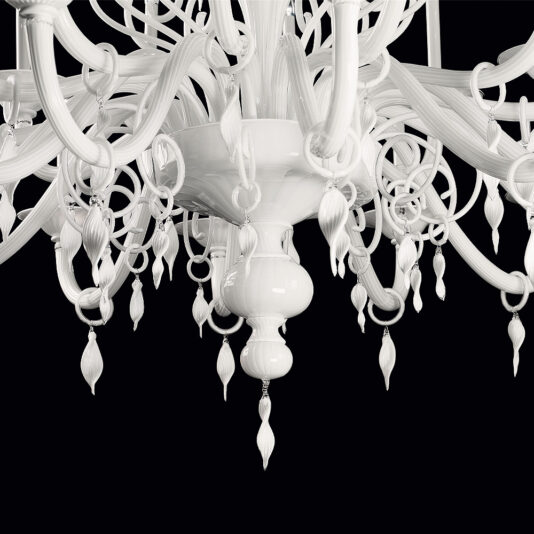 Traditional Three-Tier White Glass Chandelier A close-up view of the Traditional Three-Tier White Glass Chandelier showcases its intricate details and multiple curved arms, each adorned with decorative elements. The chandelier is set against a black background, highlighting its elaborate design.
