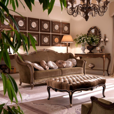 Venetian Style Button Upholstered Coffee Table A luxurious living room is depicted with an elegant tufted sofa adorned with plush pillows, a Venetian Style Button Upholstered Coffee Table, and ornate wooden furniture. A chandelier hangs from the ceiling, while a wall showcasing decorative plates adds a sophisticated touch. Plants provide refreshing greenery to the space.
