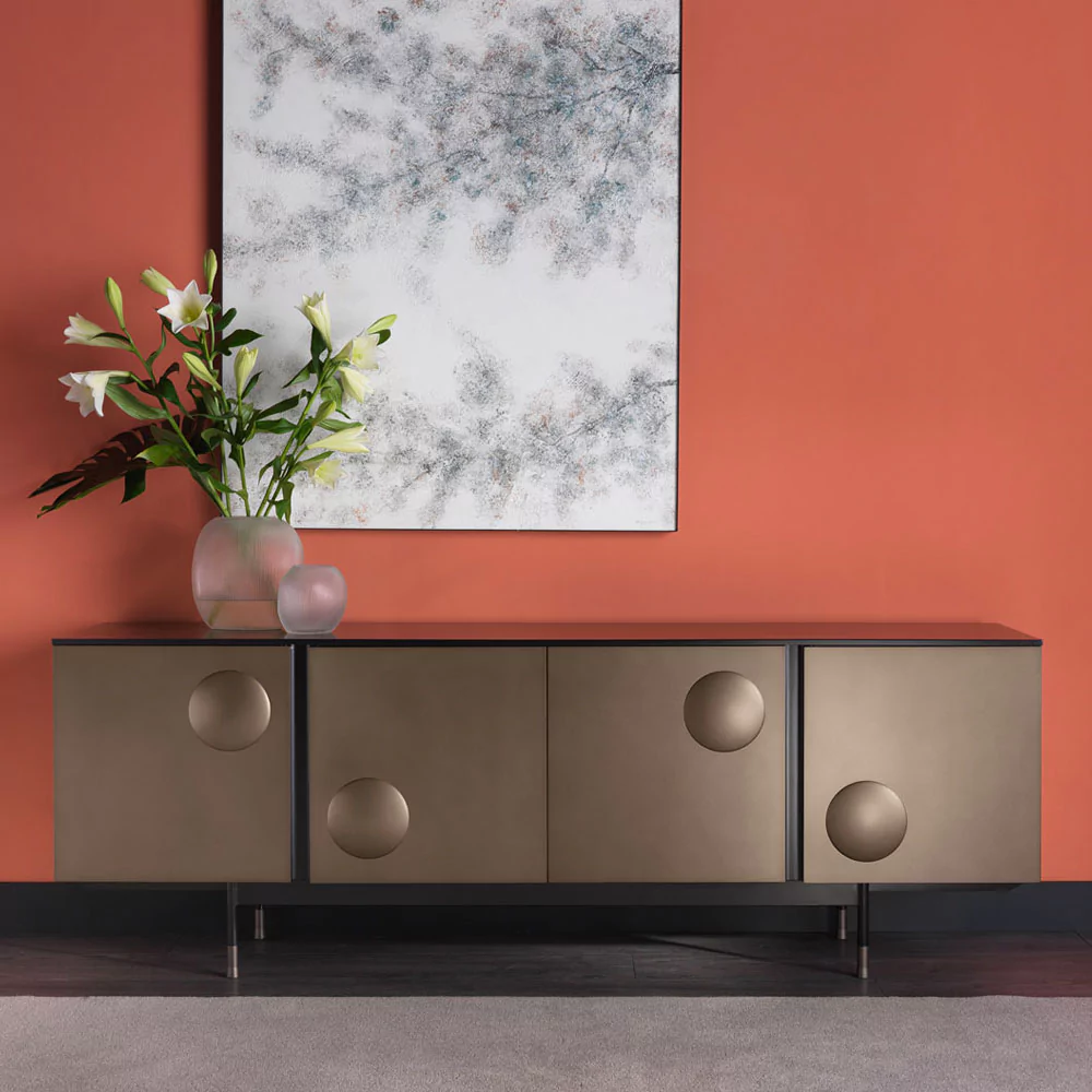 Entryway with luxury brown sideboard, orange wall, flowers and decorative artwork 