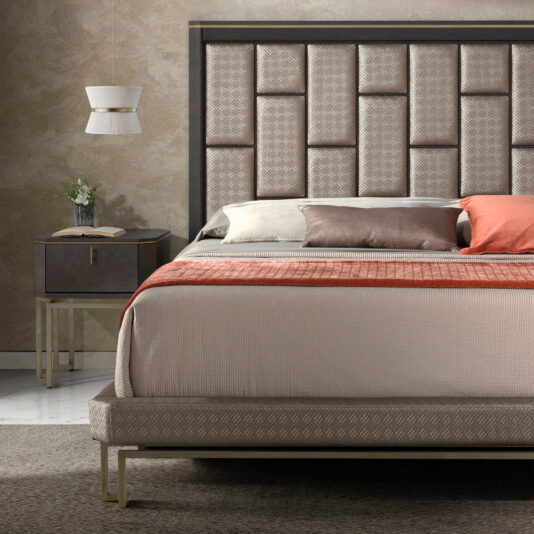 Modern Geometric Veneer Bedside Table A contemporary bedroom featuring a bed with a large, tufted headboard, neutral-colored linens, and an orange blanket. There's a sleek Modern Geometric Veneer Bedside Table with a vase of flowers and a hanging lamp, all set against a textured wall and light marble flooring.