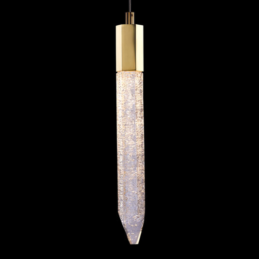 A vertically hanging pendant light features a cylindrical metallic gold top and an elongated, textured, crystal-style glass body that gently tapers to a point at the bottom. The light is turned on, illuminating the intricate design of the glass.