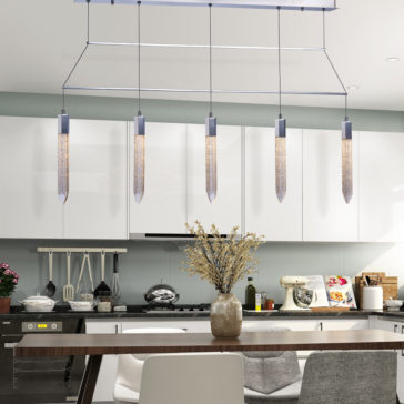 Exclusive Chrome Pendant Light Bar The modern kitchen features white cabinets and a clean, minimalist design. An **Exclusive Chrome Pendant Light Bar** elegantly illuminates a wooden dining table paired with white and gray chairs. A vase with dried flowers serves as the centerpiece on the table, while appliances and kitchenware can be seen in the background.