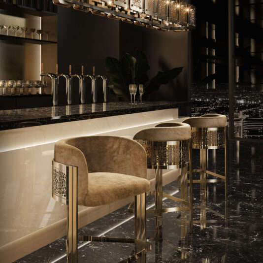 Exclusive Curved Bar Stool A modern, elegant bar area with exclusive Curved Bar Stools featuring plush upholstery and metal accents, a polished marble countertop, dim ambient lighting, and several taps behind the bar. The setting showcases a sleek, luxurious environment with a cityscape visible through a window.