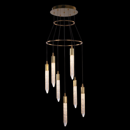 The Exclusive Gold Pendant Light Cluster is a modern chandelier boasting a circular gold base and seven elongated, faceted crystal pendants suspended at varying lengths. Each pendant emits a soft, glowing light that creates an elegant and luxurious appearance against a black background.