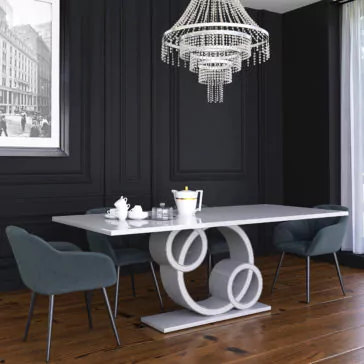Exclusive Marble Dining Table A sleek dining area showcases the Exclusive Marble Dining Table, distinguished by its unique circular base. Surrounding it are four dark upholstered chairs, while a chic crystal chandelier hangs above. The dark paneled wall is adorned with black and white cityscape artwork, and a large window allows natural light to flood in.