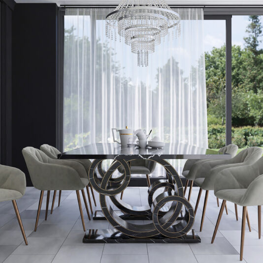 A modern dining room showcases the Exclusive Rectangular Marble Dining Table, which boasts a unique abstract metal base. Surrounding it are eight light gray cushioned chairs with wooden legs. Above the table hangs a large, elegant crystal chandelier, and floor-to-ceiling windows dressed in sheer white curtains reveal a lush green garden outside.